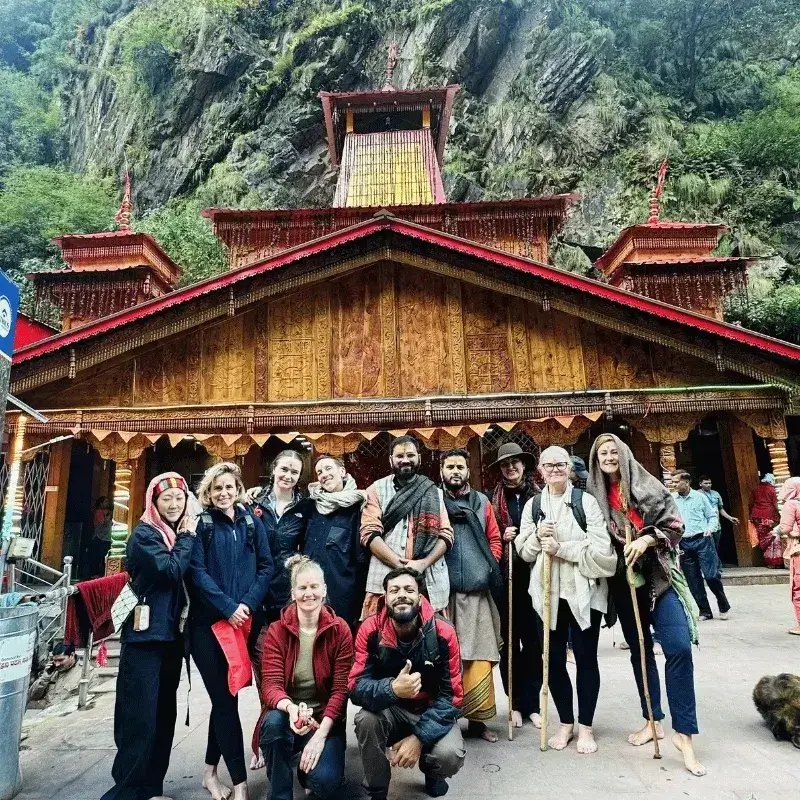 Group photo of international clients outside the beautiful wooden Yamunotri temple, included in our all-inclusive Chardham package.