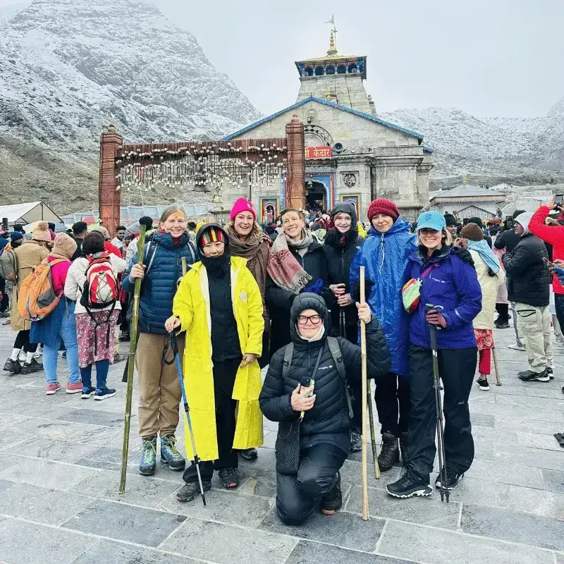 Group image of international tourists at snow-covered Kedarnath temple, captured during our Chardham yatra package.